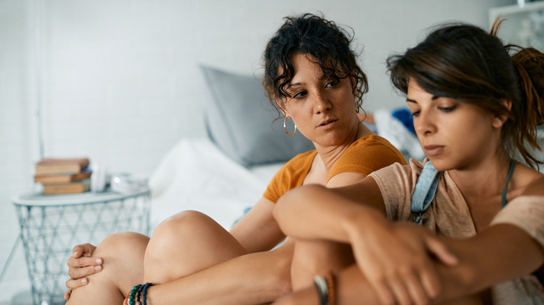 two women talking on bed