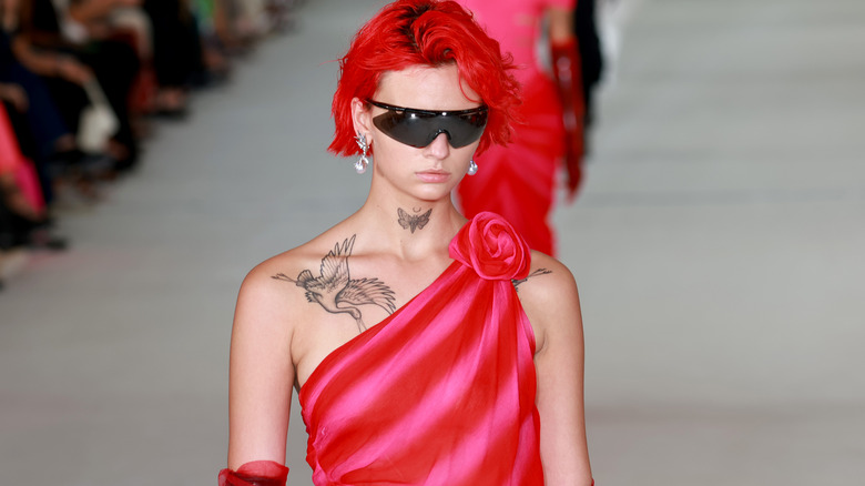 model with bright red hair on the runway