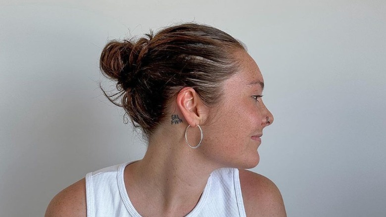 Woman wears messy slicked-back bun