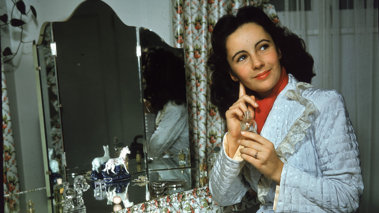 Elizabeth Taylor applying perfume