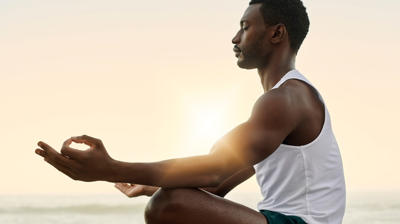 Man meditating on the beach