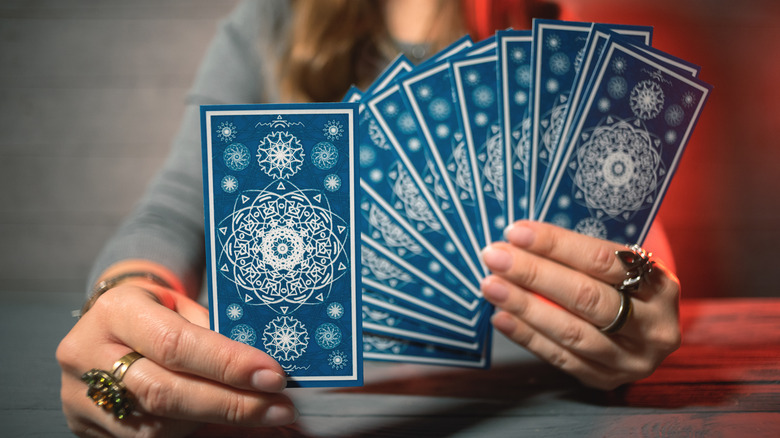 Person holding tarot card deck