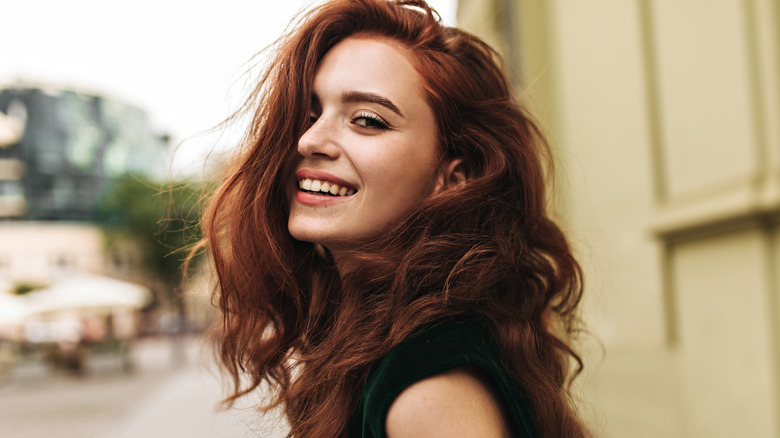 Woman with wavy red hair outside