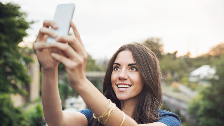 Woman taking selfie outside 