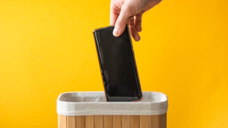 Person putting smartphone in basket