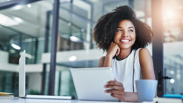 Woman thinking, smiling at work