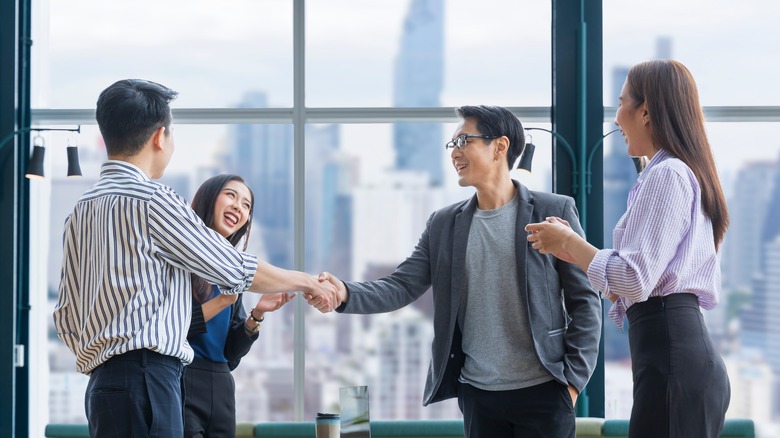 People shaking hands in office