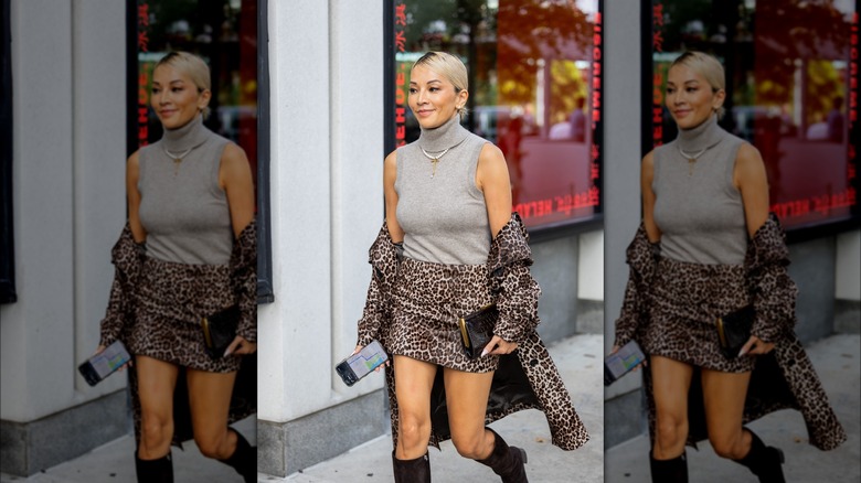 Woman in animal print skirt and high neck top