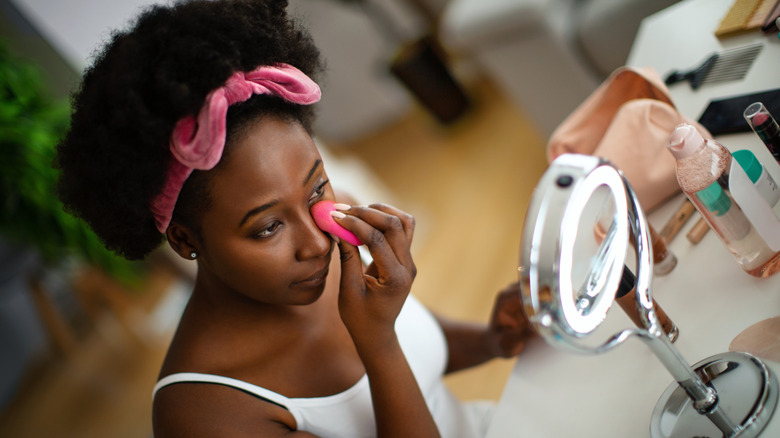 woman blending under eye concealer