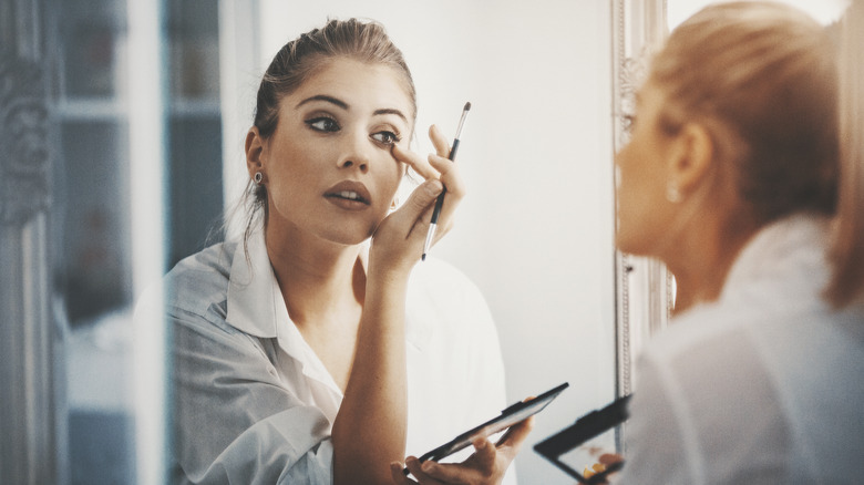 woman applying eye concealer brush