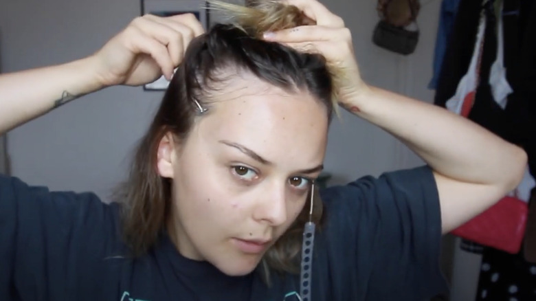 YouTuber demonstrates how to part hair to apply face tape