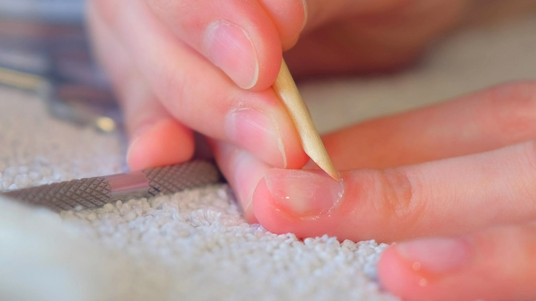 woman holding cuticle stick