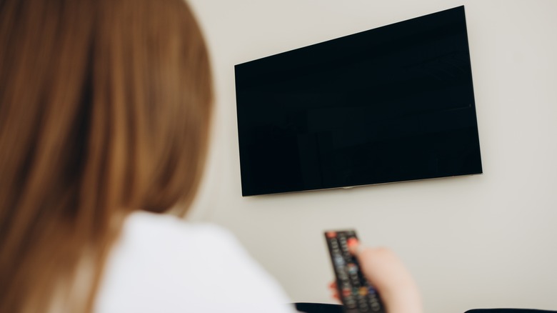 woman turning off TV