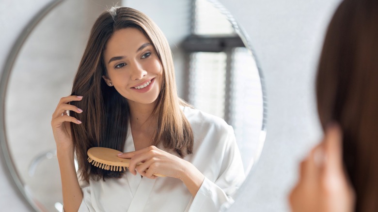 smiling woman looking in a mirror