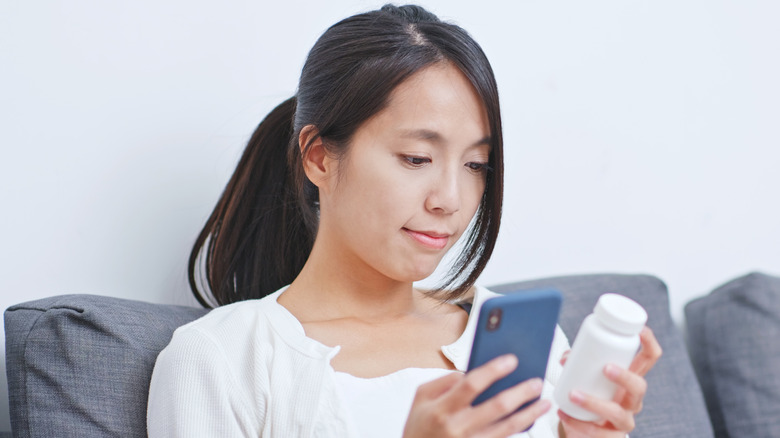 woman researching medicine on phone