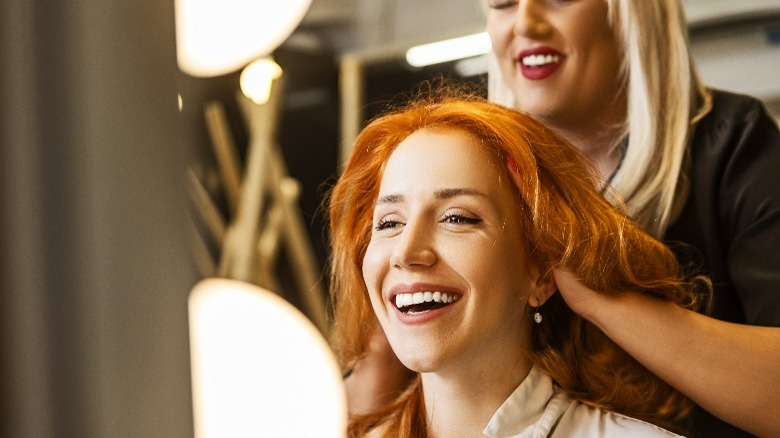 Happy woman getting hair styled