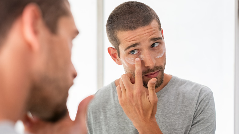 man applying eye cream