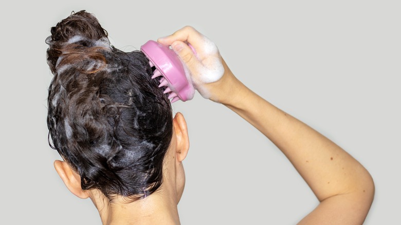 Woman using silicone head massage tool