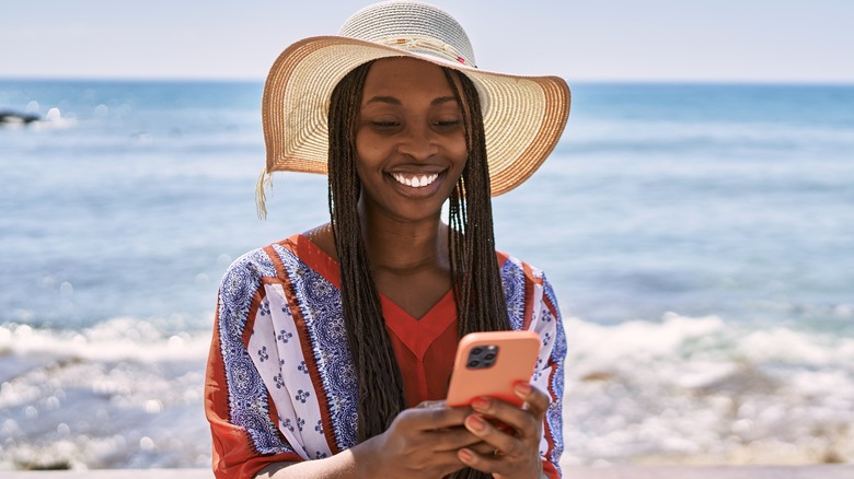 woman using phone on beach