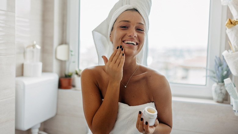 woman applying moisturizer around mouth