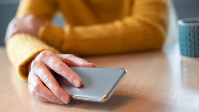 Hand putting down phone on table