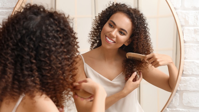 Woman combing curly hair 