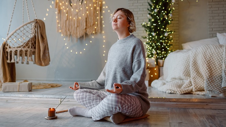 Woman meditating near holiday decorations