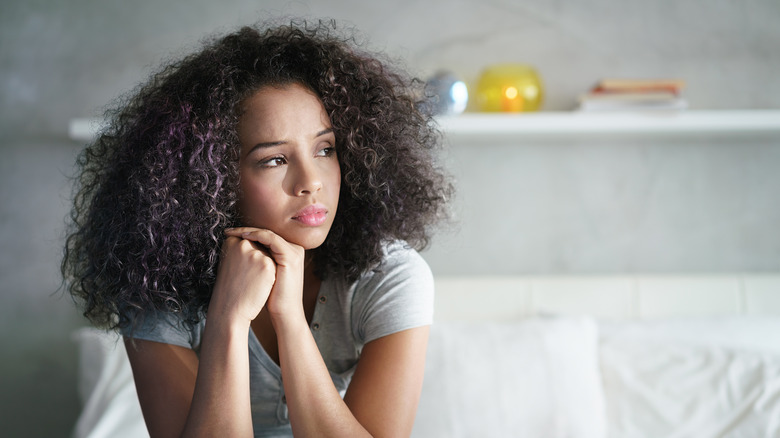 sad woman sitting on bed