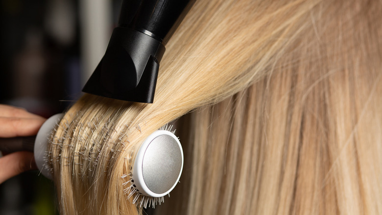 Woman drying hair with brush