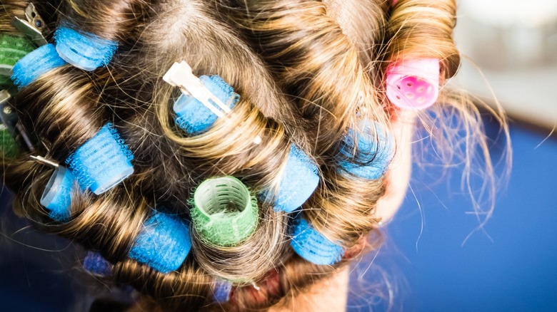 Person with curlers in hair