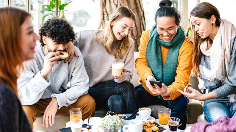 friends talking and laughing drinking coffee