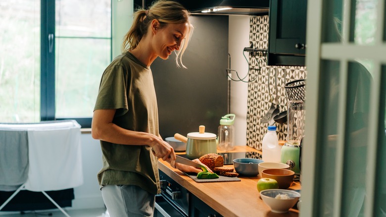 happy woman prepping food in kitchen