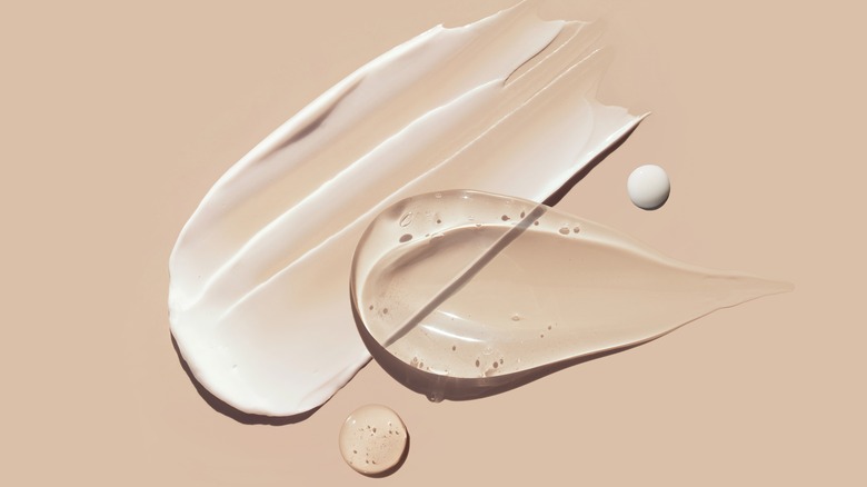 Cosmetic products smeared on beige background