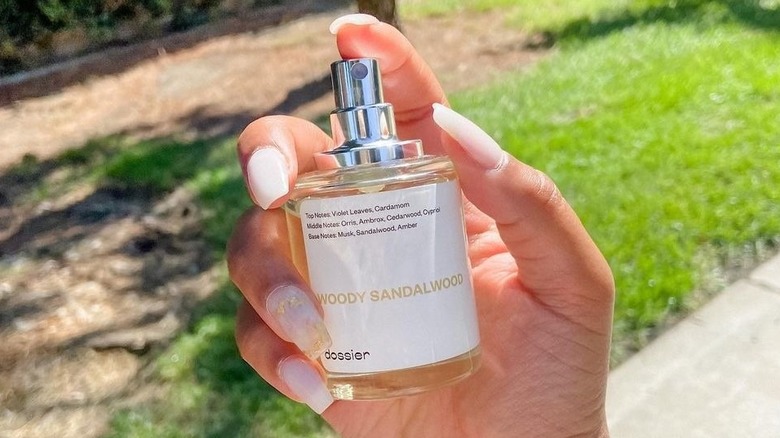 Hand holding Dossier Woody Sandalwood fragrance