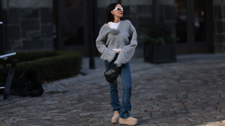 Woman wearing chunky sweater and jeans