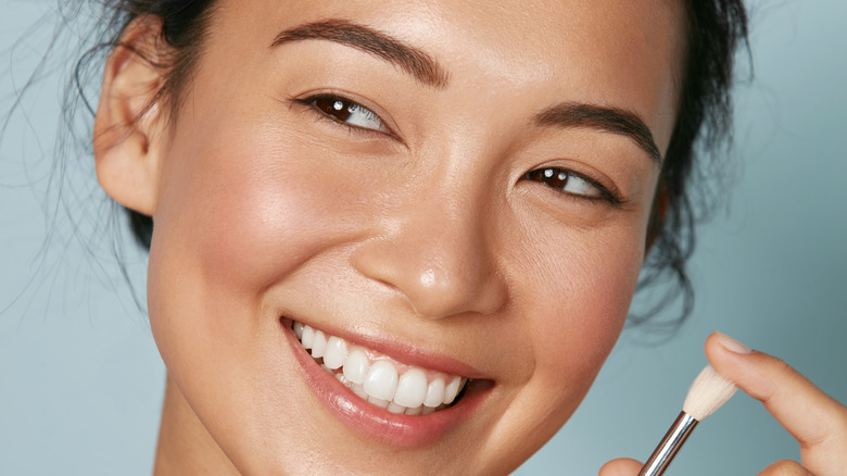 woman holding makeup brush