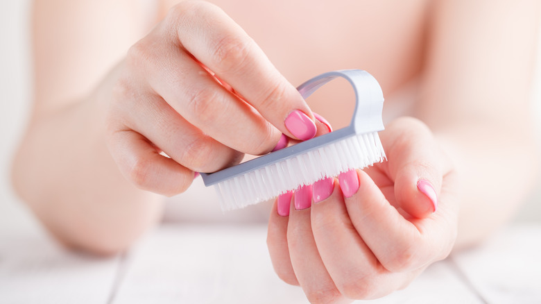 woman cleaning nails with a brush