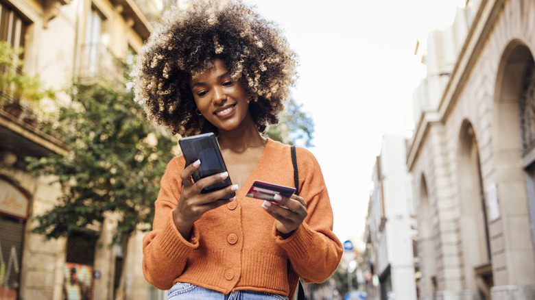 Woman holds phone and credit card