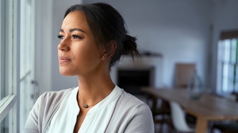 Pensive woman looking out window