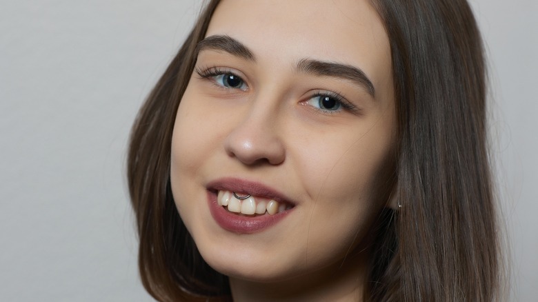 Woman sits after frenulum piercing