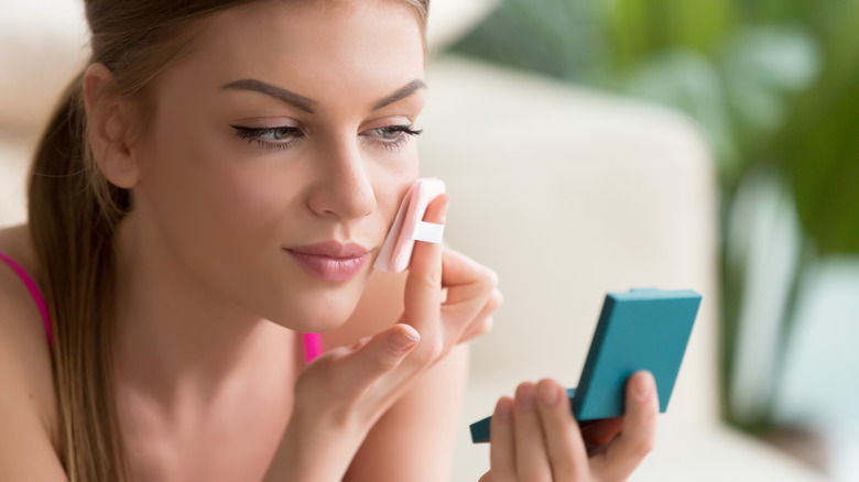 woman applying pressed powder foundation