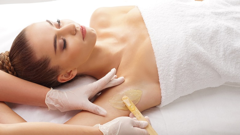 Woman having her armpits waxed