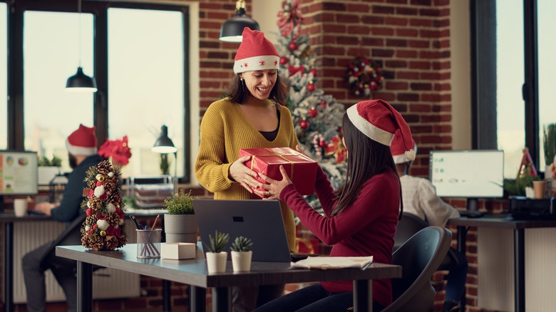 Coworkers exchanging xmas gifts at office