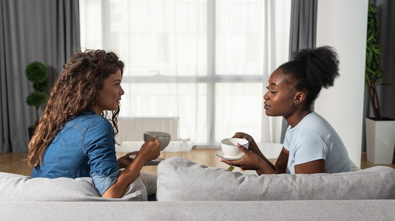 two friends talking on sofa