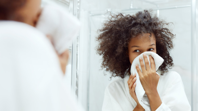 woman in bathroom drying face