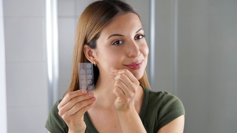 woman applying pimple patch