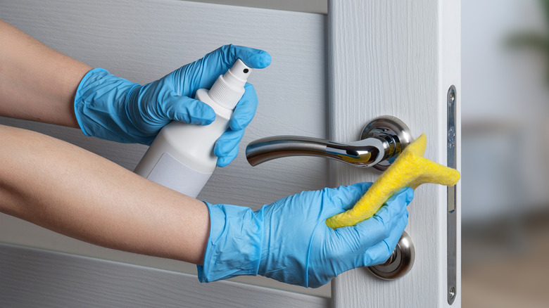 cleaning door handle wearing gloves