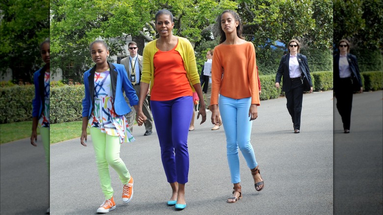 Michelle Obama walking with her daughters