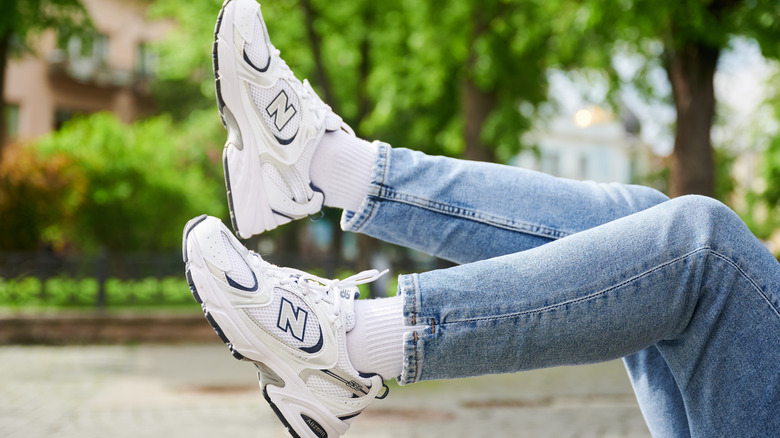 A person wearing New Balance sneakers and jeans