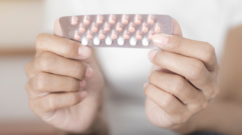 Woman holding oral contraceptive